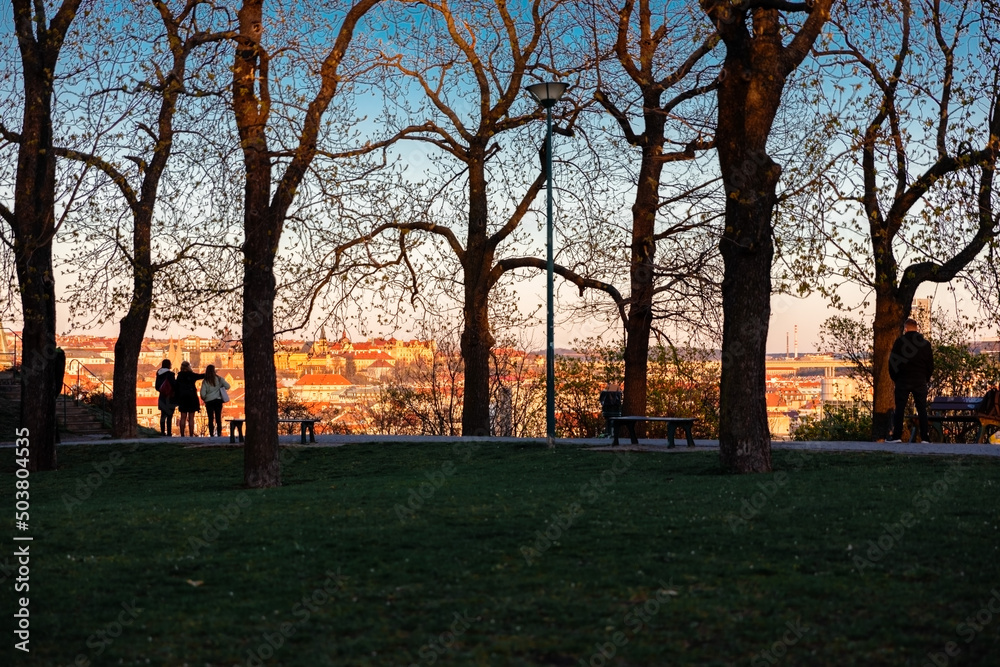 People watching sunset in popular park. Angel, Prague, Czech Republic. Silhouettes of people and trees on beautiful view of city. People watching sunset in popular park. Angel, Prague, Czech Republic. Silhouettes of people and trees on beautiful view of city.