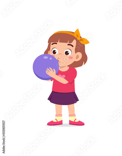 little kid standing and blowing a balloon