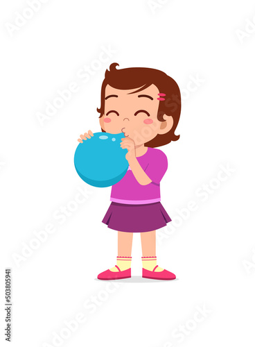 little kid standing and blowing a balloon