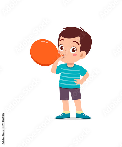 little kid standing and blowing a balloon
