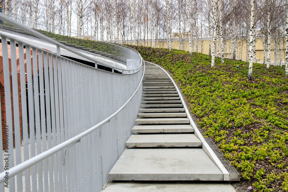 Tall modern winding staircase with railings in a birch grove. GES-2