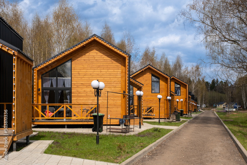 Fototapeta Naklejka Na Ścianę i Meble -  A group of houses in the same style. Trendy modern barnhouse style houses. bright blue sky