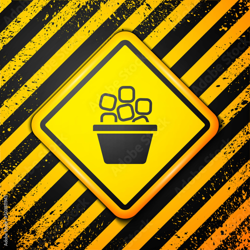 Black Ice bucket filled with ice cubes icon isolated on yellow background. Warning sign. Vector
