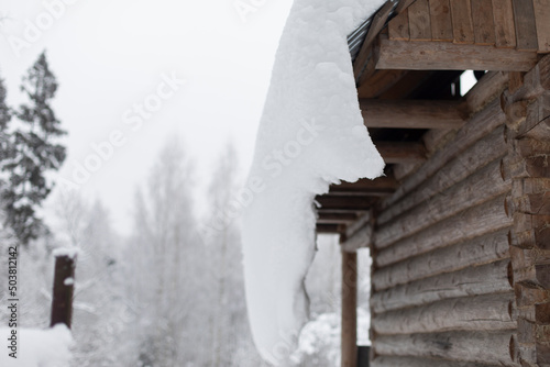 Snow on roof. Village in winter. Details of houses in village.