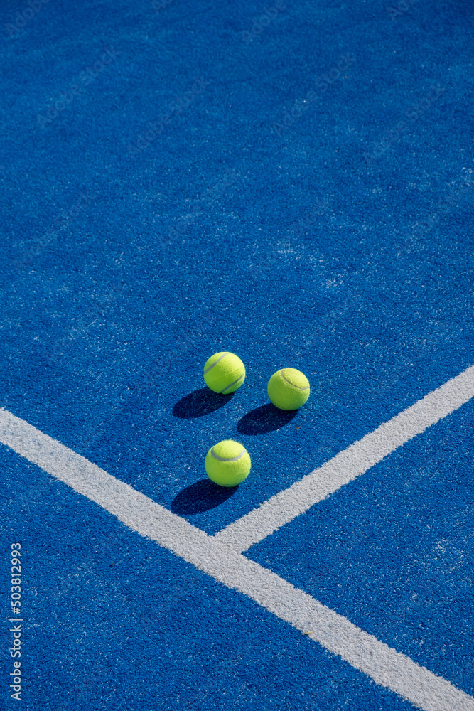 Three balls an the net of a paddle tennis court. Selective focus.