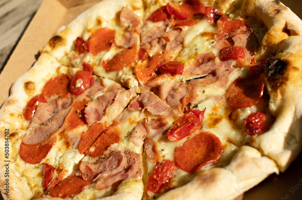Pizza in a cardboard box on a dark chalkboard. Space for your text. Top view of pizza package. Pizza delivery. Pizza in a cardboard box on a dark chalkboard. Space for your text. Top view of pizza package. Pizza delivery.