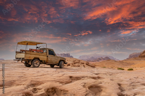 Old bedouin car with sandstones sunset landscape of Wadi Rum desert, Jordan