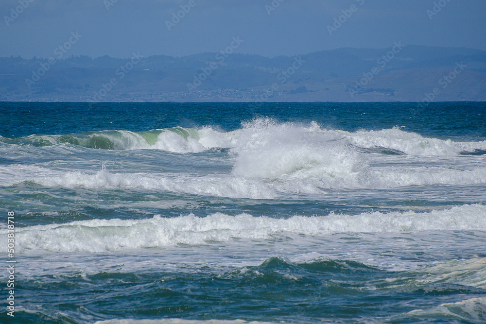 Crashing surf on a beautiful Pacific Ocean Beach beneath the bright blue sky