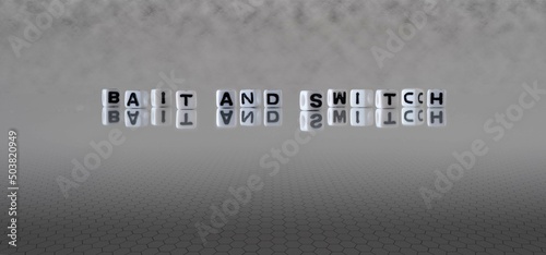 bait and switch word or concept represented by black and white letter cubes on a grey horizon background stretching to infinity