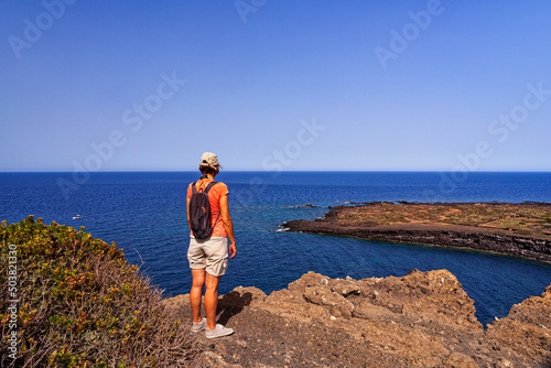Woman looking the sea from the top of the volcano called Monte Nero, Linosa. Sicily © bepsphoto