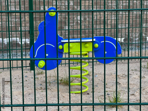 Spielgerät auf kleinem umzäunten Spielplatz  photo