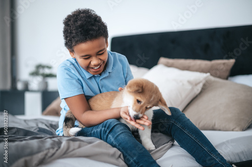 A boy having fun with his dog and looking excited