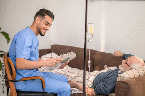 In-home nurse entertaining a patient on the IV drip