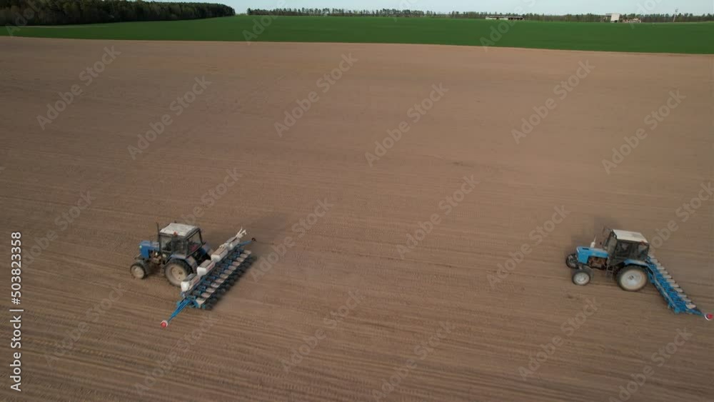 Tractor sowing seed on plowed field, drone view. Seeding machinery for plowing field. Seed sowing and soil cultivating.Tractor with disk harrow on plowing field. Ploughing and seeding with tractors.
Tractor sowing seed on plowed field, drone view. Seeding machinery for plowing field. Seed sowing and soil cultivating.Tractor with disk harrow on plowing field. Ploughing and seeding with tractors.
