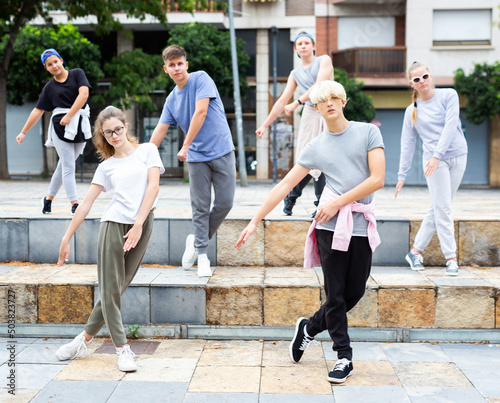Group of dancing teenagers posing at city street. Hip hop dancers