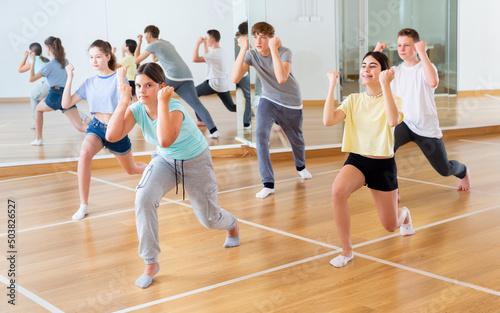 Boys and girls learn to dance modern dances in dance studio © JackF