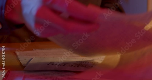 A close-up of the hands of an employee of the secret police examines the document, takes paper out of the envelope, examines it. Folds and puts in the inside pocket. Collection of human data.