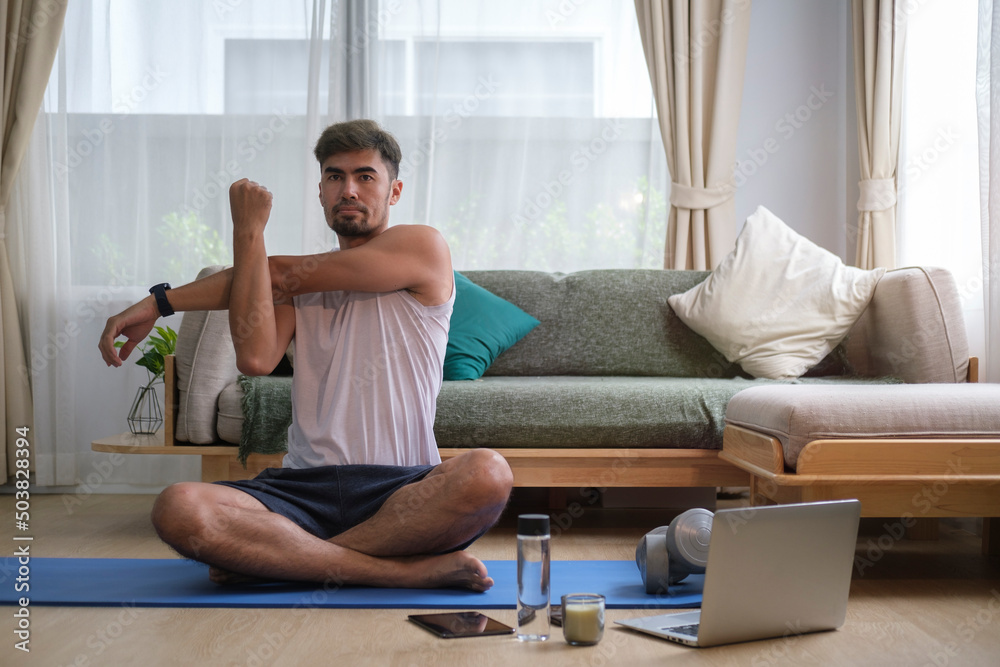 Young man stretching arms before workout at home. Fitness and healthy lifestyle. Fitness and healthy lifestyle. Young man stretching arms before workout at home. Fitness and healthy lifestyle. Fitness and healthy lifestyle.