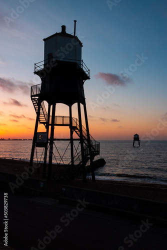 beach sunrise with seaside lighthouse