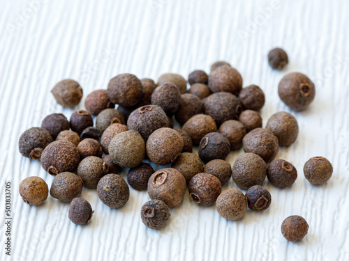 Allspice background. Handful of Jamaican pepper, pimento berry, allspice peppercorns or myrtle pepper. closeup, full frame, food backgound, copy space.