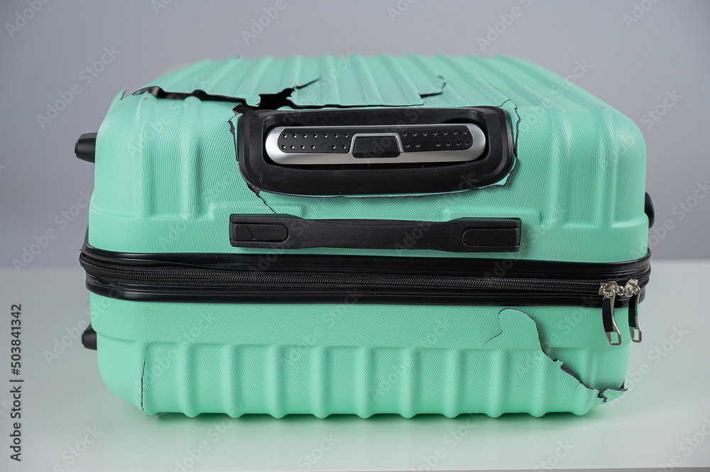 Broken plastic mint suitcase on a white background. 