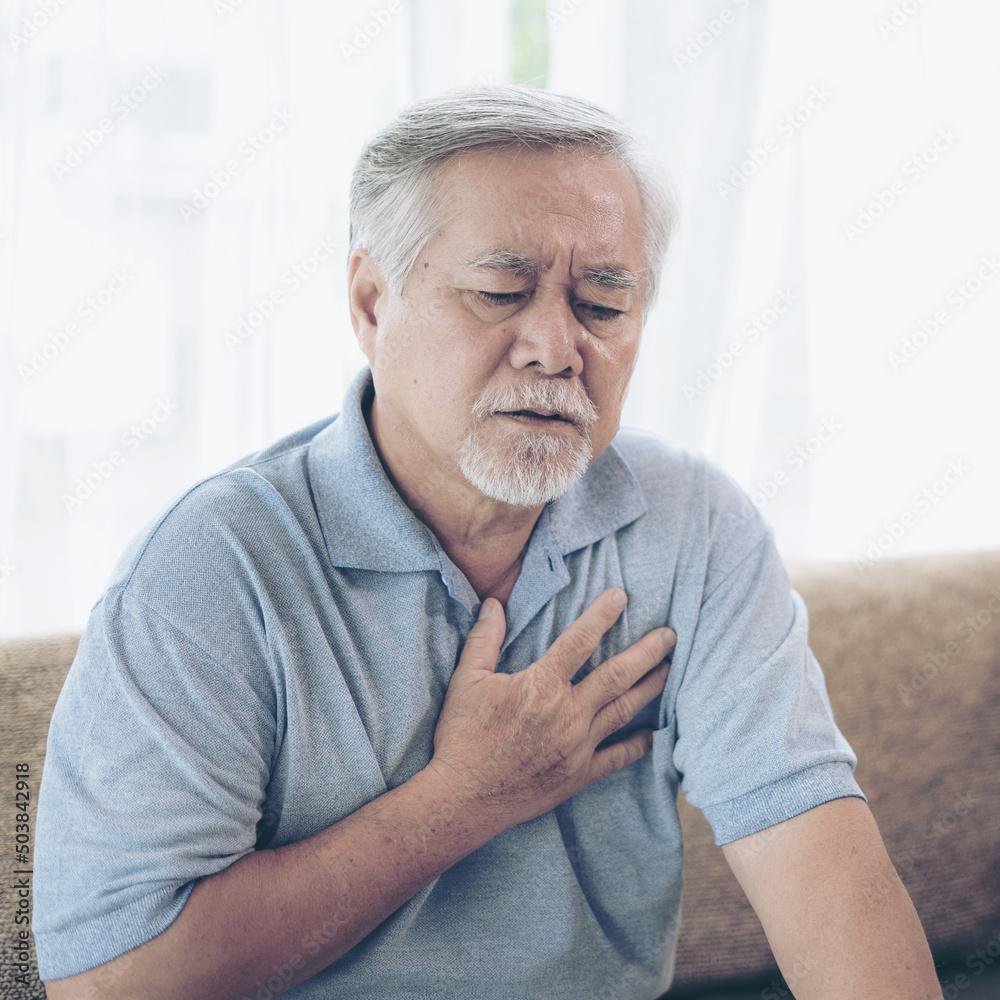 Senior male asian suffering from bad pain in his chest heart attack at home - senior heart disease