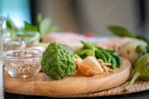 Focusing on bergamots are placed  among Thai spicies on wood circle plate. photo