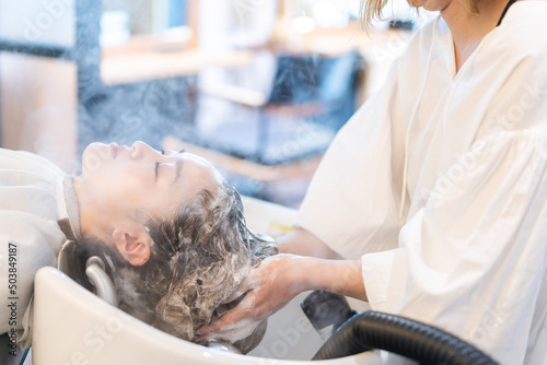 A woman receiving a steam treatment at a hair salon