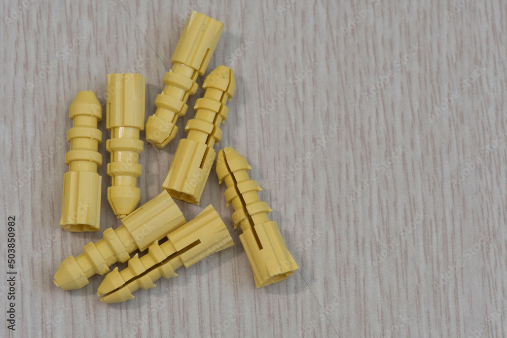 Closeup of yellow expansion tubes used for mounting items on drywall.