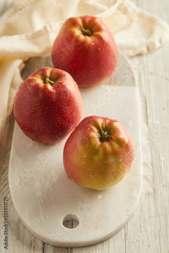 red apples on white plate on wooden table 