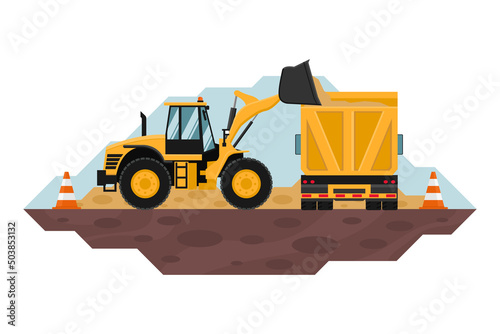 Front loader filling a dump truck with safety cones, heavy machinery used in the construction and mining industry