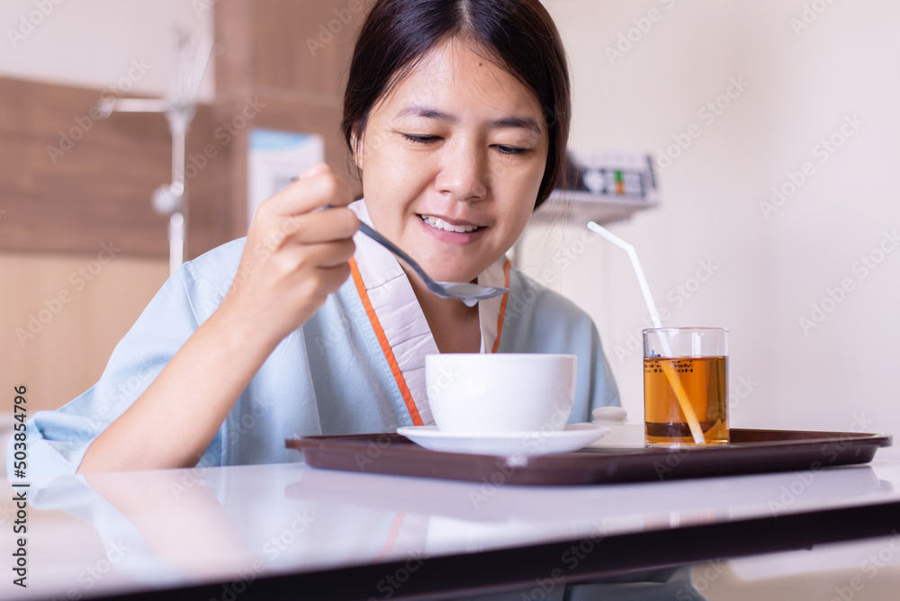 Sick asian woman patient eating meal on sickbed in the hospital Sick asian woman patient eating meal on sickbed in the hospital