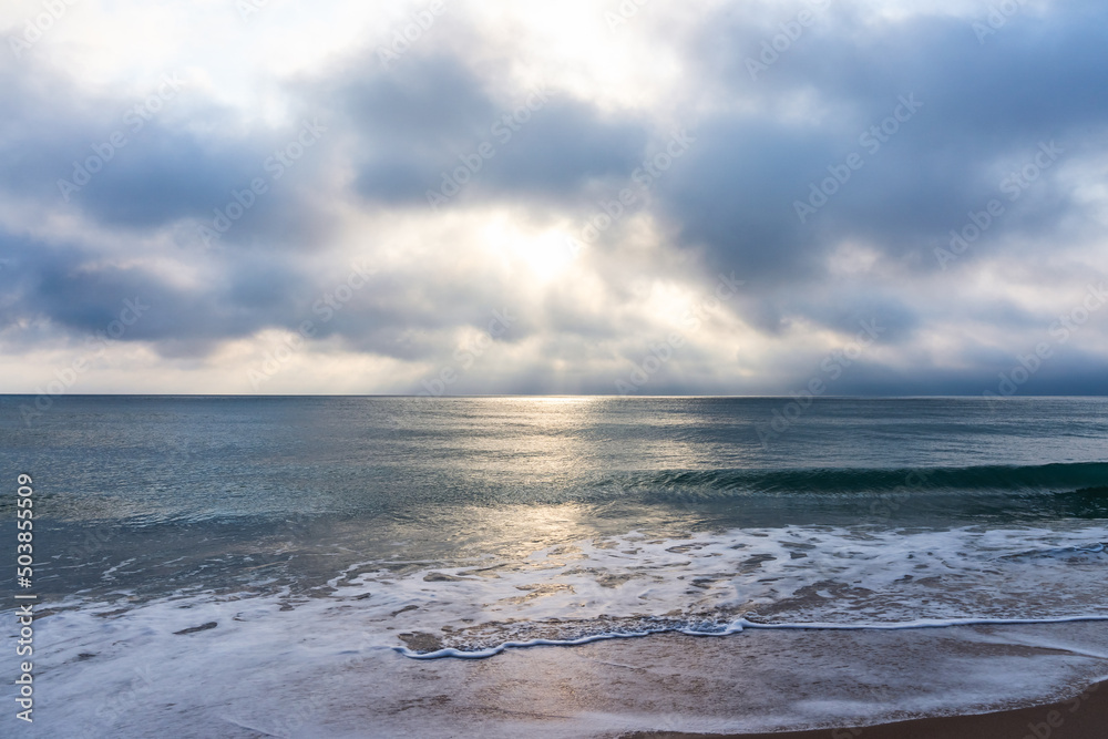 Sunrise over the Atlantic Ocean in Florida. Calm water, leaden ocean, lush clouds. Soothing view, relaxation