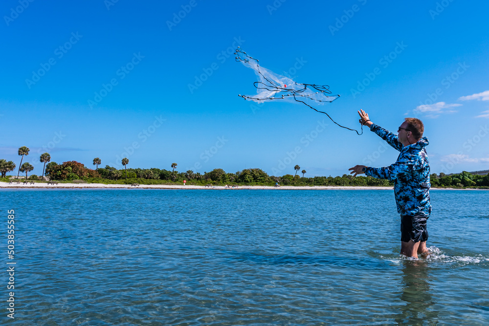 An elderly man throws a Cast Net for Bait in saltwater of the Gulf of  Mexico, Florida Stock Photo