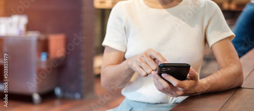 Casual Businesswoman holding and using smartphone for sms messages  young woman typing touchscreen mobile phone in cafe or modern office. lifestyle  technology  Social media and network concept