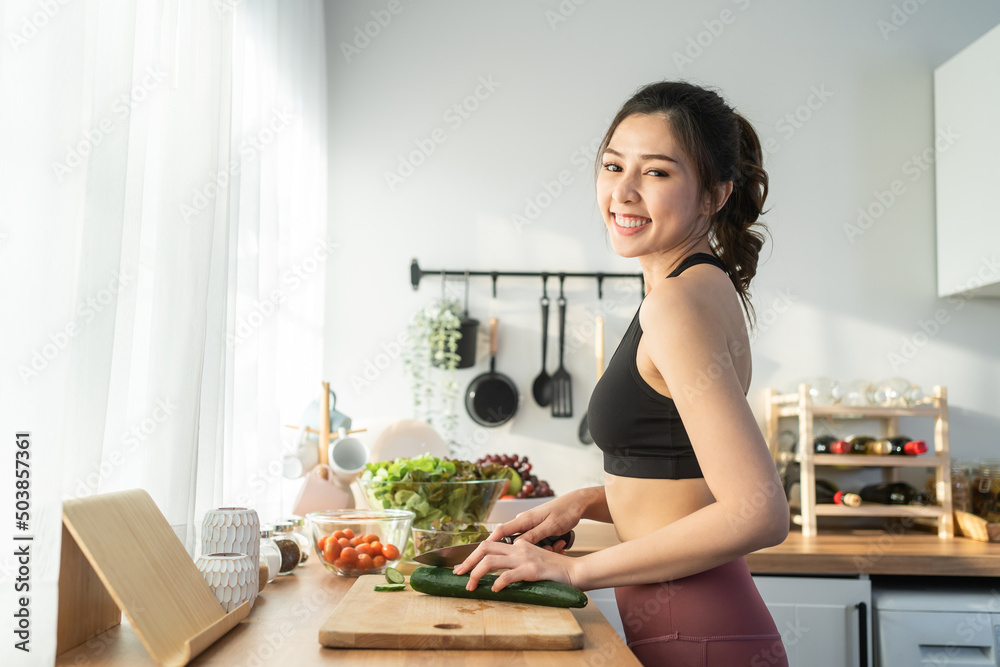 Portrait of Asian attractive woman cooking salad and look at camera