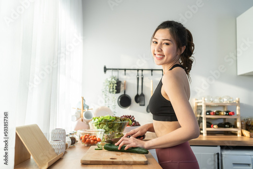 Portrait of Asian attractive woman cooking salad and look at camera