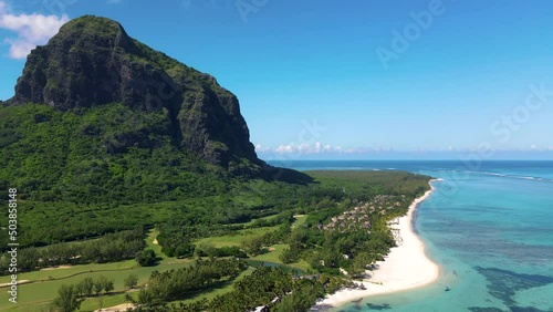 Le Morne beach Mauritius Tropical beach with palm trees and white sand blue ocean and beach beds with umbrellas, sun chairs, and parasols under a palm tree at a tropical beach. Mauritius Le Morne photo
