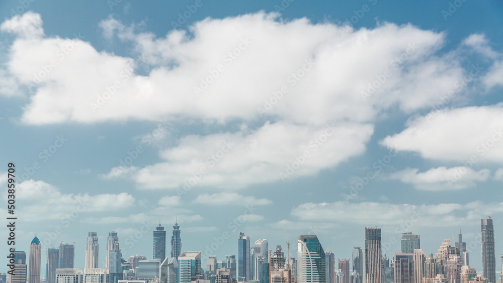 Cloudy sky over skyline with modern architecture of Dubai business bay towers timelapse. Aerial view
