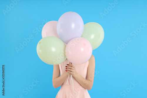 Concept of Happy Birthday  young woman with balloons on blue background