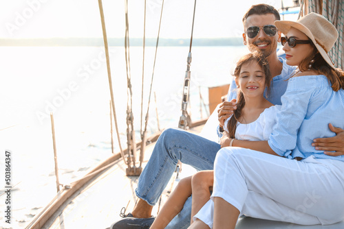 Happy young family resting on yacht