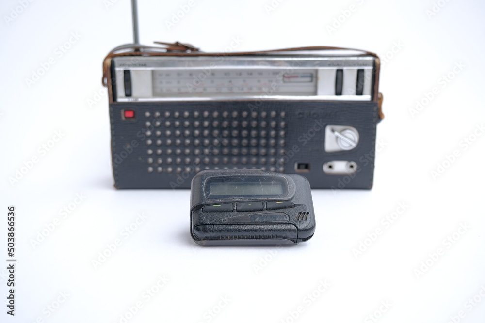 pager, old vintage beeper. the pager lies on an old retro radio with an antenna