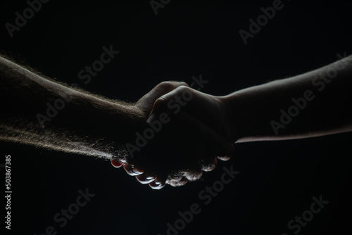 Handshake between the two partners, agreement. Male hands rescue. Friendly handshake, friends greeting, friendship. Rescue, helping gesture or hands. Helping hand.