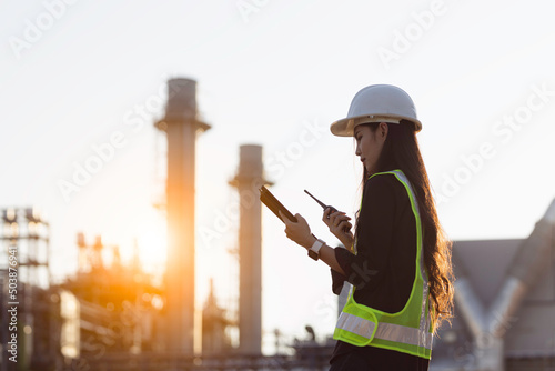 Wallpaper Mural An asia woman industrial engineer in Hard Hat uses a laptop computer while standing in a heavy industrial factory in the background various metal parts project lying. Torontodigital.ca