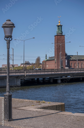 Lamp pool at a stone pier with Town City Hall in background a sunny spring day in Stockholm © Hans Baath