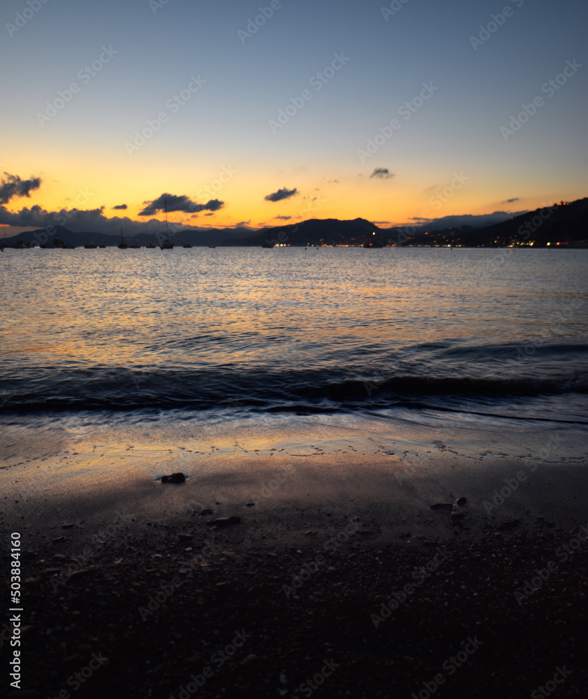 Fototapeta premium incredible colors and lights, a romantic sunset on the beach facing the sea in the magnificent Liguria