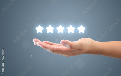 Fotografie, Tablou Hand review customer feedback glowing rating five star service best product quality of ranking evaluation rate or user experience good satisfaction and excellent business success on vote background