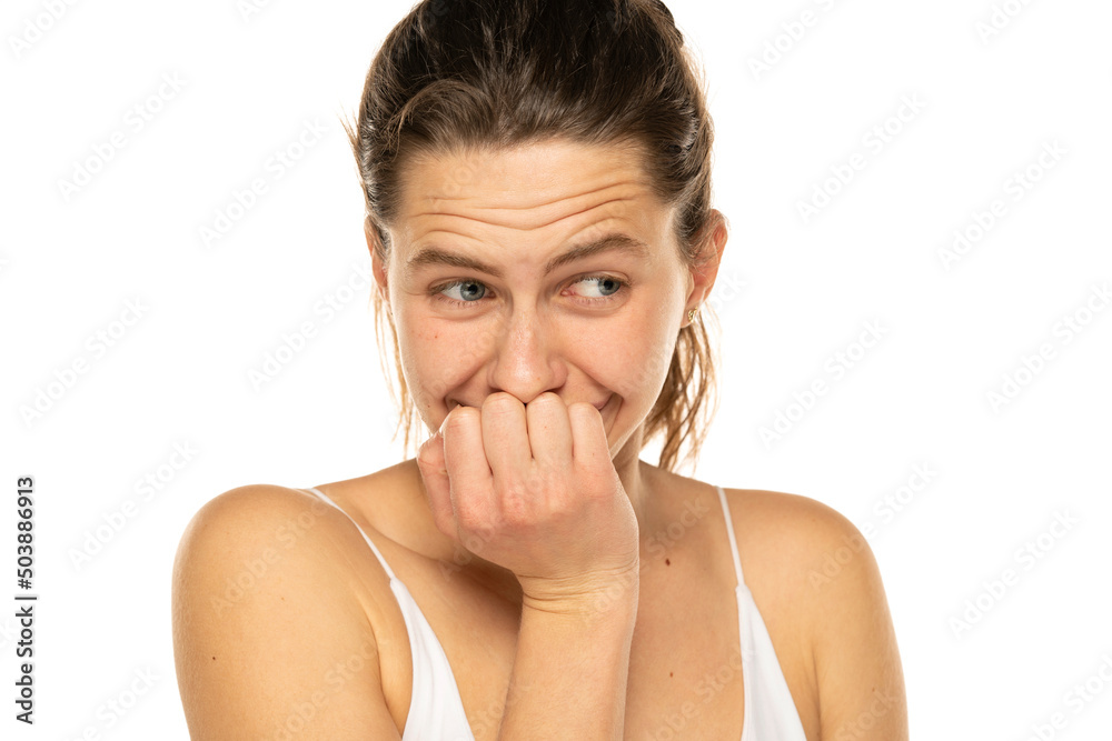 Embarrassed young woman laughing and covering mouth with hand on a white background Embarrassed young woman laughing and covering mouth with hand on a white background