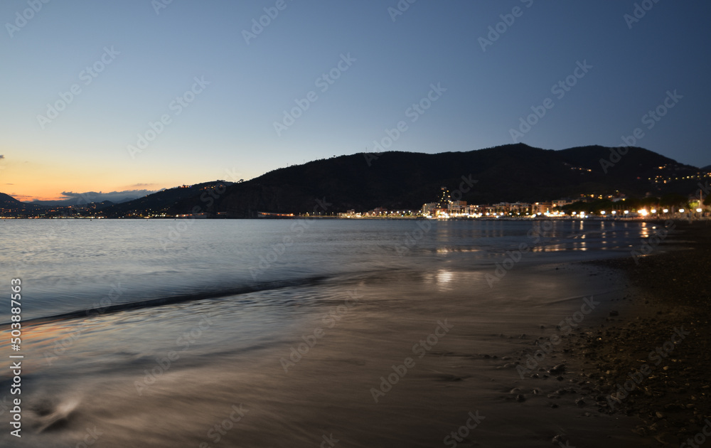 incredible colors and lights, a romantic sunset on the beach facing the sea in the magnificent Liguria