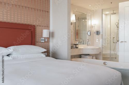 Elegant and comfortable home and hotel bedroom interior.The bathroom can be seen through the glass in the bedroom.